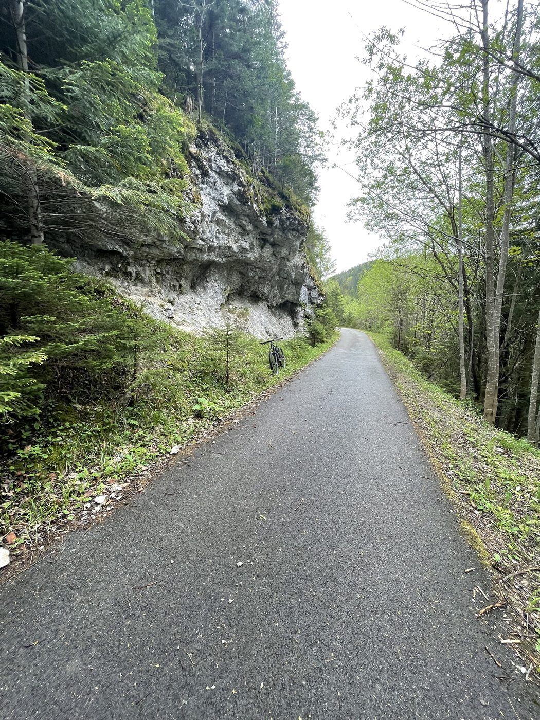 Asfaltová cyklotrasa popod skalnú stenu v doline