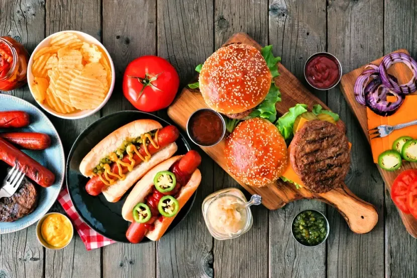 Burgre, hotdogy a grilované jedlo na drevenom stole