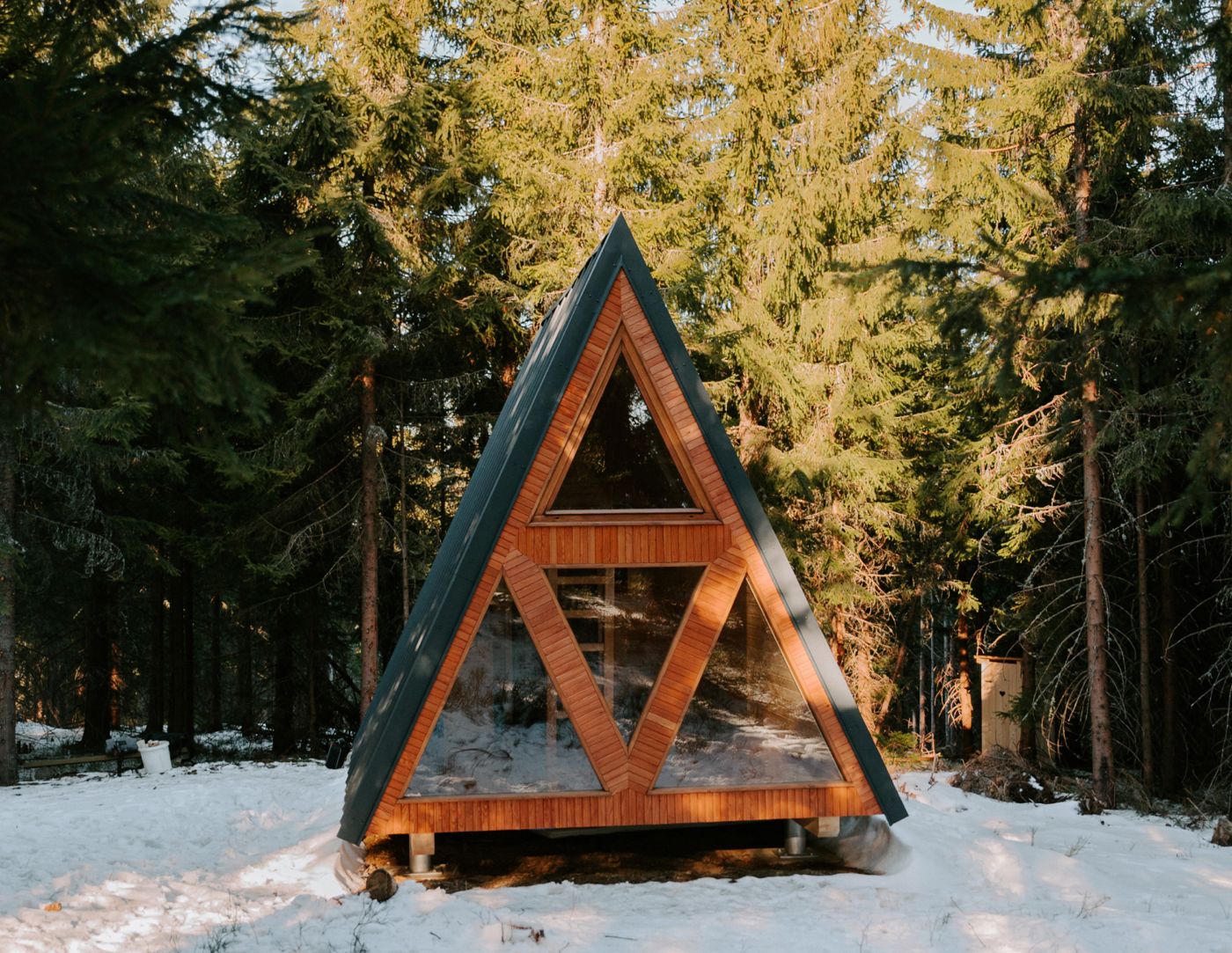 A-frame wooden shelter in a snowy forest